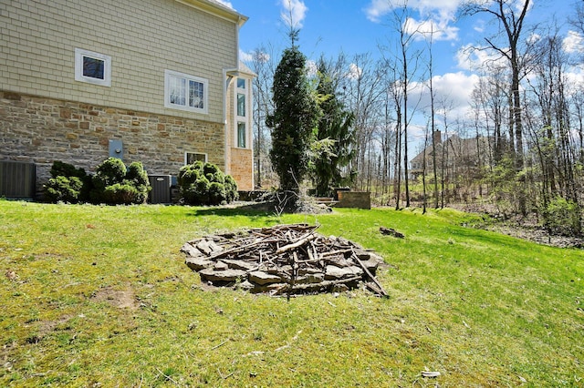 6795 Macneil Dr, Dublin, OH 43017 - view of yard featuring central air condition unit and an outdoor fire pit