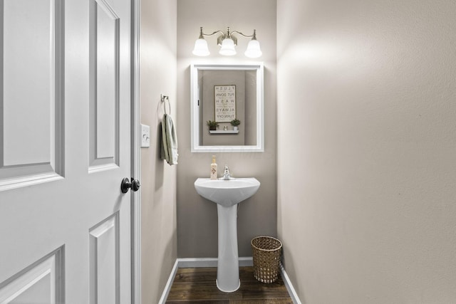 bathroom with baseboards and wood finished floors