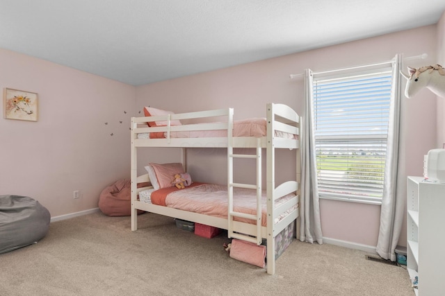 carpeted bedroom featuring baseboards and visible vents