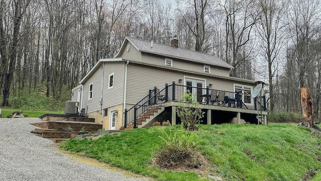 rear view of house featuring a chimney, a deck, stairway, and central AC