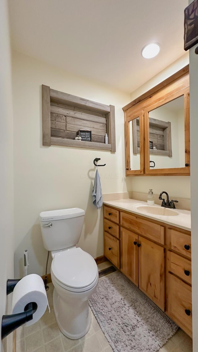 bathroom featuring toilet, recessed lighting, vanity, and baseboards
