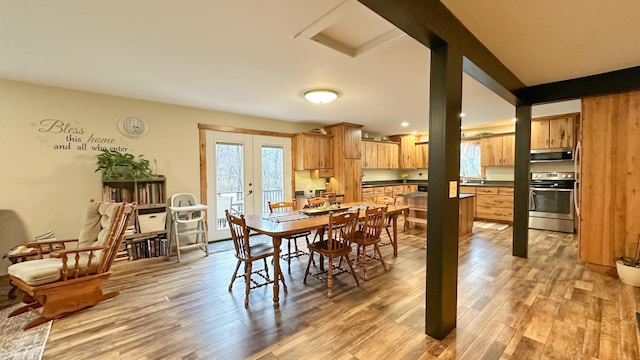 dining space with light wood-type flooring and french doors