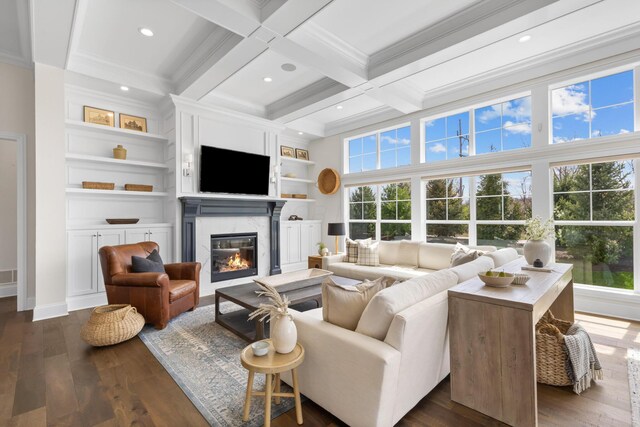 living area with beamed ceiling, a high end fireplace, dark wood-style floors, and ornamental molding