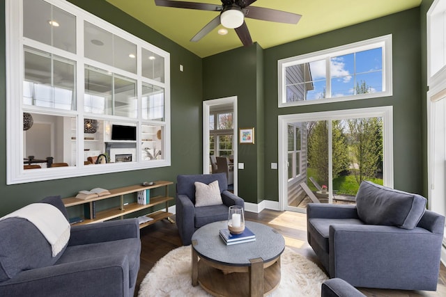 living room featuring a high ceiling, a ceiling fan, wood finished floors, and recessed lighting