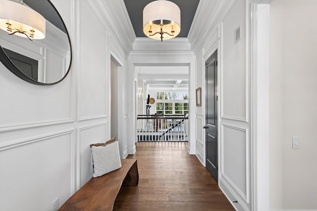 corridor featuring crown molding, dark wood-style floors, visible vents, and a decorative wall