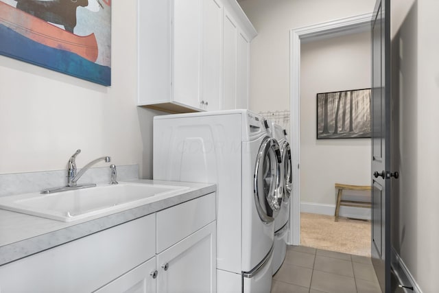 laundry area with washer and clothes dryer, a sink, light tile patterned flooring, cabinet space, and light colored carpet