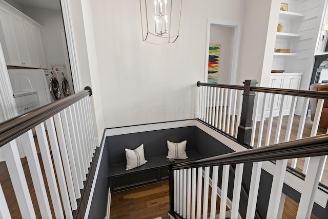 stairs featuring wood finished floors and a notable chandelier