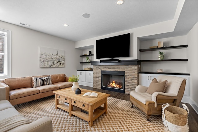 living room featuring recessed lighting, light wood-style floors, visible vents, and a fireplace