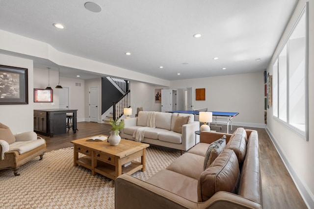 living area with stairway, baseboards, wood finished floors, and recessed lighting
