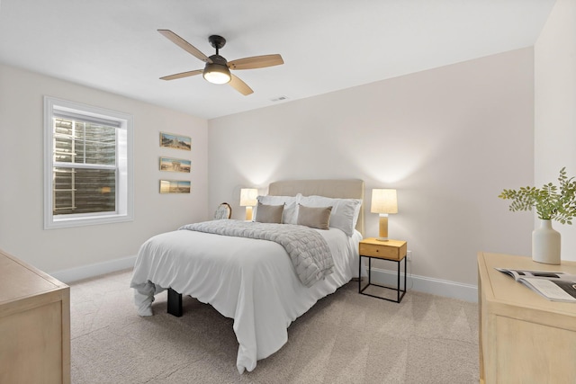 bedroom featuring baseboards, visible vents, light colored carpet, and ceiling fan