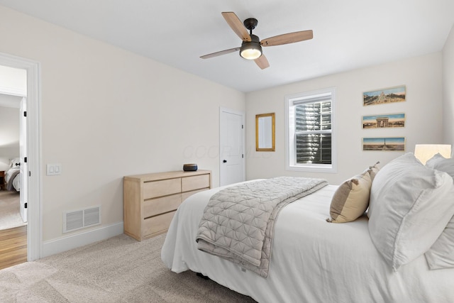 bedroom with baseboards, a ceiling fan, visible vents, and light colored carpet