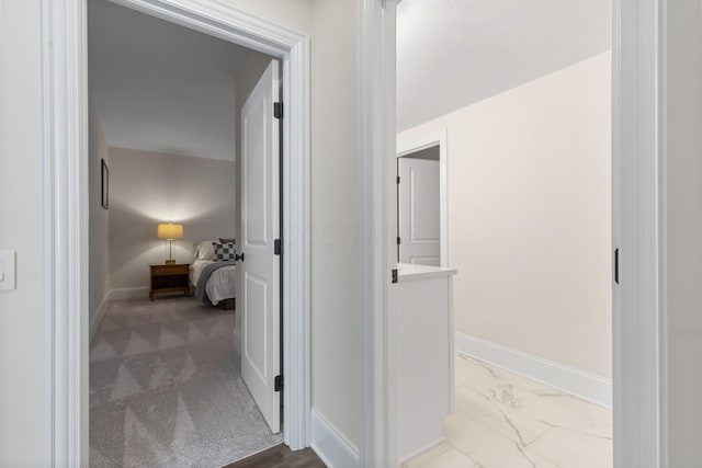 hallway with marble finish floor and baseboards