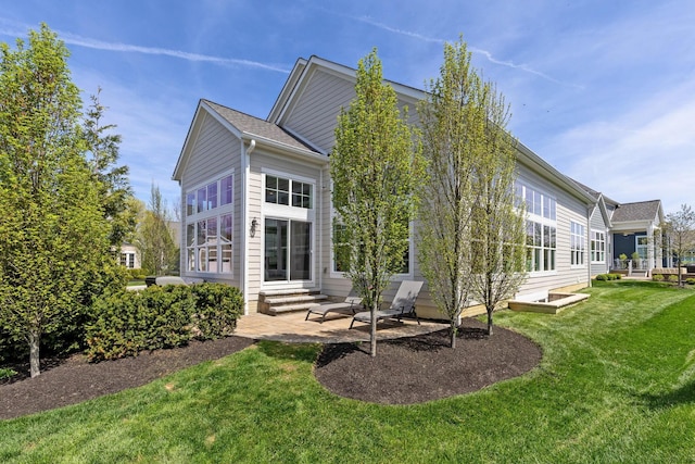 rear view of house with a yard, a patio, and entry steps