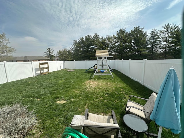 view of yard with a fenced backyard and a playground