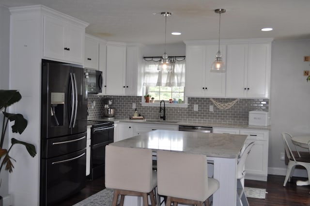kitchen featuring backsplash, white cabinets, black appliances, dark wood finished floors, and a sink