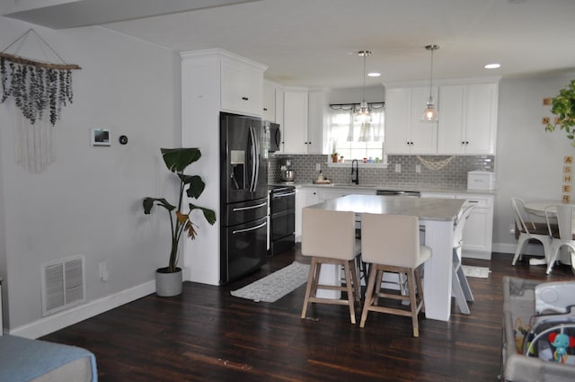 kitchen featuring fridge with ice dispenser, visible vents, a sink, light countertops, and black / electric stove
