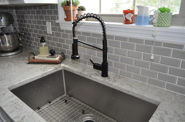 details featuring tasteful backsplash and a sink