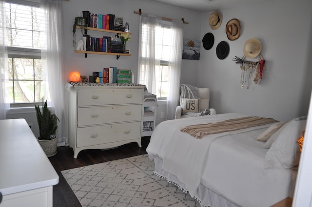 bedroom featuring dark wood finished floors and multiple windows