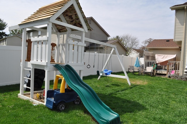 view of jungle gym featuring fence and a lawn