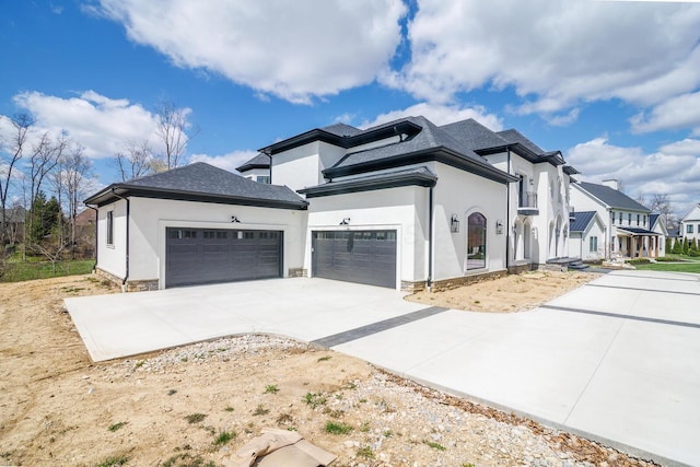 view of side of property with an attached garage, concrete driveway, and stucco siding