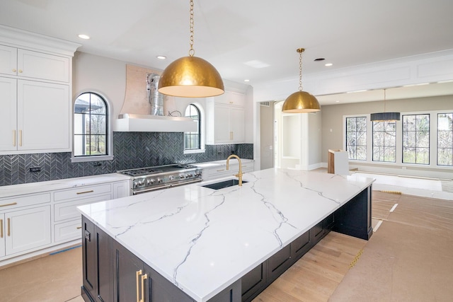 kitchen featuring tasteful backsplash, stainless steel range, a sink, white cabinetry, and custom range hood