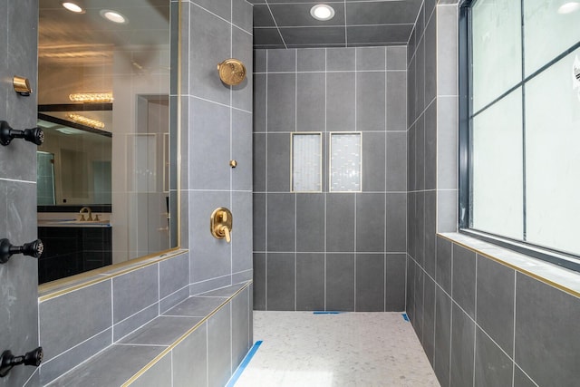 bathroom featuring recessed lighting, tiled shower, and vanity