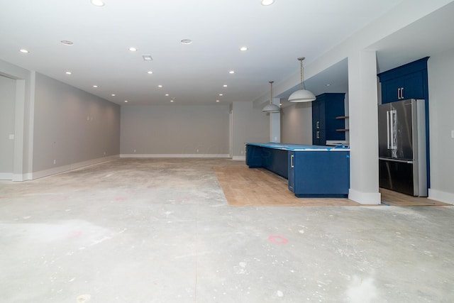 unfurnished living room with concrete floors, baseboards, and recessed lighting