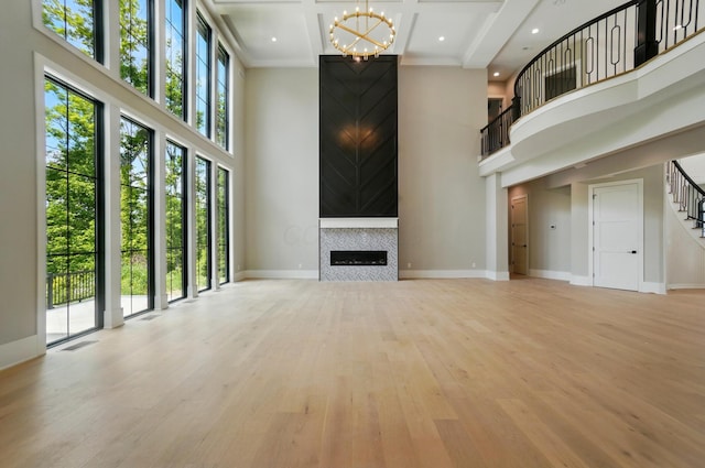 10007 Allen Dr, Dublin, OH 43017 - unfurnished living room featuring a high ceiling, a chandelier, healthy amount of natural light, light wood finished floors, and baseboards
