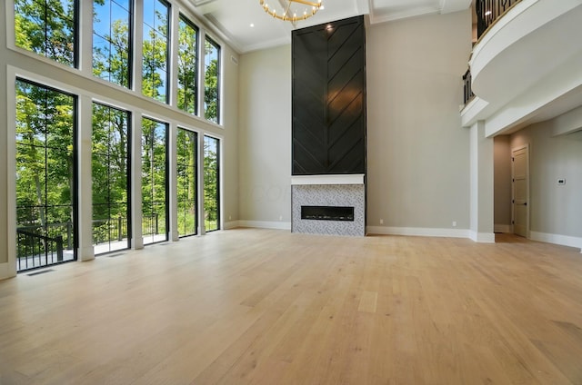 10007 Allen Dr, Dublin, OH 43017 - unfurnished living room with a towering ceiling, light wood finished floors, baseboards, healthy amount of natural light, and a tile fireplace