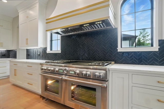 10007 Allen Dr, Dublin, OH 43017 - kitchen with double oven range, custom exhaust hood, white cabinetry, decorative backsplash, and light wood-type flooring