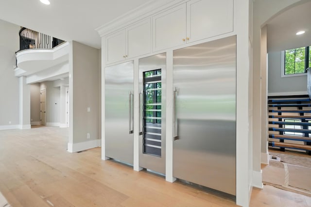 10007 Allen Dr, Dublin, OH 43017 - kitchen with stainless steel built in refrigerator, arched walkways, light wood-type flooring, white cabinetry, and recessed lighting