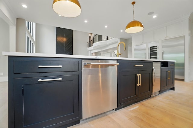 10007 Allen Dr, Dublin, OH 43017 - kitchen featuring stainless steel appliances, decorative light fixtures, light wood finished floors, light countertops, and white cabinets