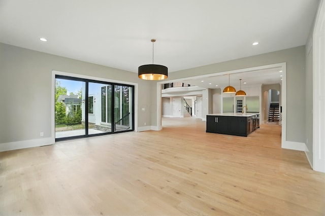 10007 Allen Dr, Dublin, OH 43017 - unfurnished living room with light wood finished floors, baseboards, arched walkways, and recessed lighting