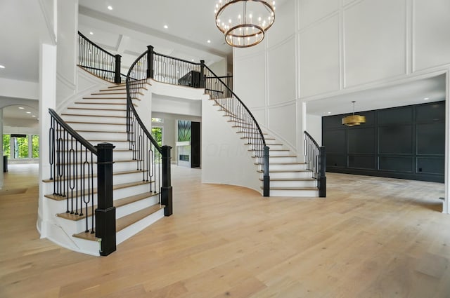 10007 Allen Dr, Dublin, OH 43017 - stairway featuring plenty of natural light, arched walkways, a high ceiling, wood finished floors, and a chandelier