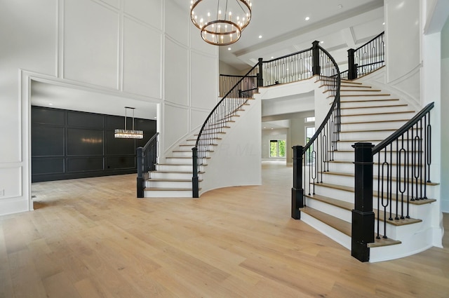10007 Allen Dr, Dublin, OH 43017 - stairway featuring a chandelier, a decorative wall, a towering ceiling, wood finished floors, and recessed lighting