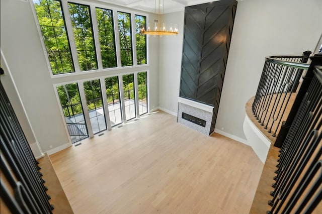 10007 Allen Dr, Dublin, OH 43017 - unfurnished living room with plenty of natural light, wood finished floors, baseboards, a chandelier, and a high ceiling