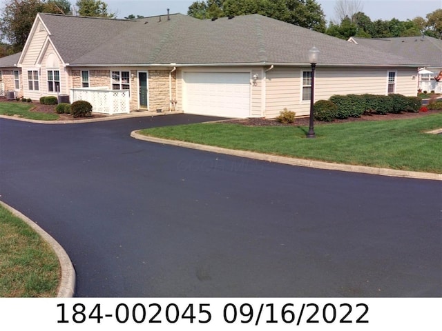 185 Groveport Pike Unit 3D, Canal Winchester, OH 43110 - view of front facade with an attached garage, driveway, a front lawn, central AC, and stone siding