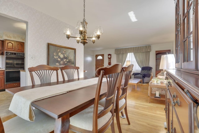 6693 Red Coach Ln, Reynoldsburg, OH 43068 - dining space with wallpapered walls, a notable chandelier, and light wood-style flooring