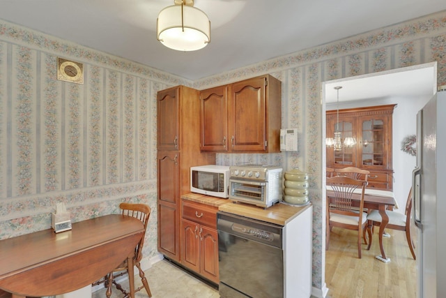 6693 Red Coach Ln, Reynoldsburg, OH 43068 - kitchen featuring brown cabinets, light wood-type flooring, white appliances, a toaster, and wallpapered walls