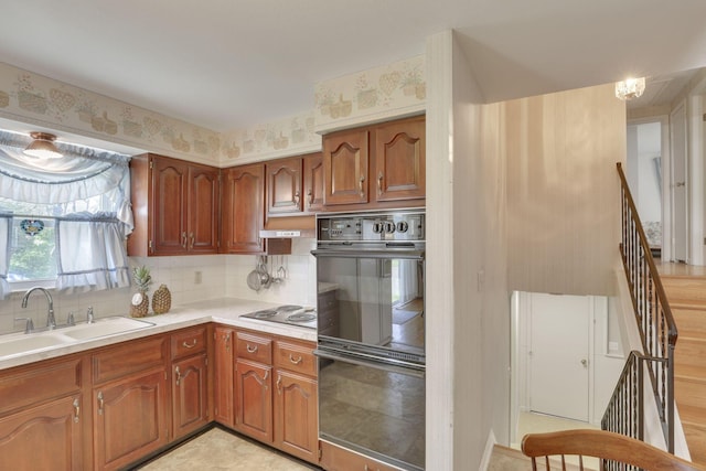6693 Red Coach Ln, Reynoldsburg, OH 43068 - kitchen with dobule oven black, a sink, light countertops, stainless steel electric stovetop, and backsplash