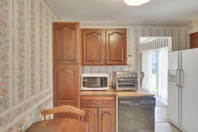 6693 Red Coach Ln, Reynoldsburg, OH 43068 - kitchen with brown cabinets, light countertops, wallpapered walls, a toaster, and white appliances
