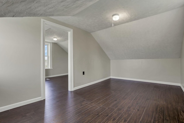 8400 16th Rd Unit Sw, Amanda, OH 43102 - bonus room featuring vaulted ceiling, baseboards, a textured ceiling, and dark wood finished floors