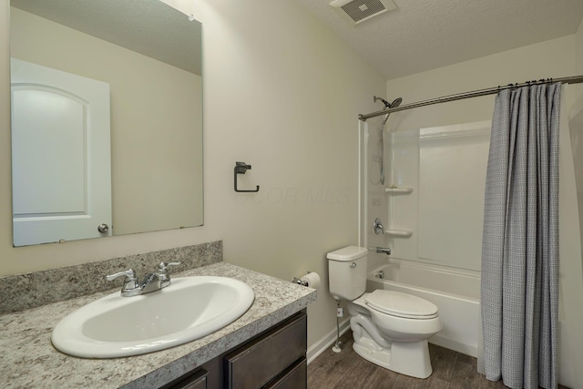 bathroom featuring visible vents, toilet, shower / bath combo with shower curtain, vanity, and wood finished floors
