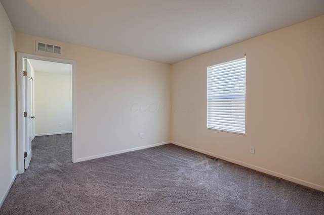 carpeted empty room with baseboards and visible vents