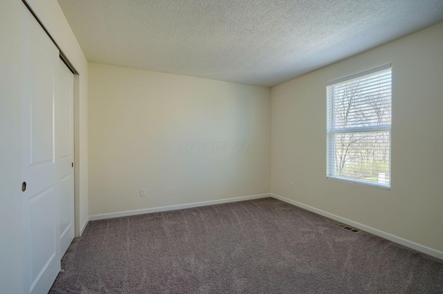 unfurnished bedroom featuring visible vents, baseboards, a closet, and carpet