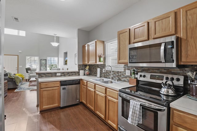 kitchen featuring visible vents, appliances with stainless steel finishes, light countertops, a sink, and backsplash