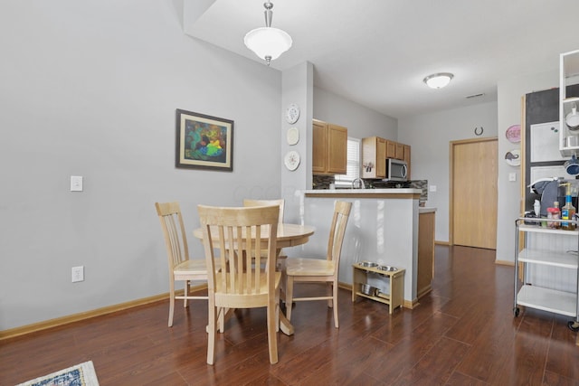 dining room featuring dark wood-style flooring and baseboards