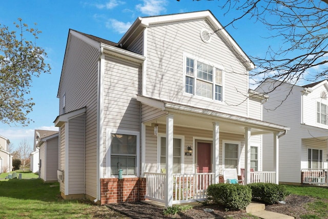 view of front of house with a porch and brick siding