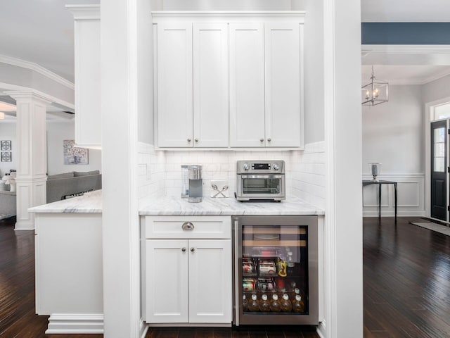 7251 Wilton Chase St, Dublin, OH 43017 - bar featuring crown molding, decorative columns, dark wood-type flooring, beverage cooler, and backsplash