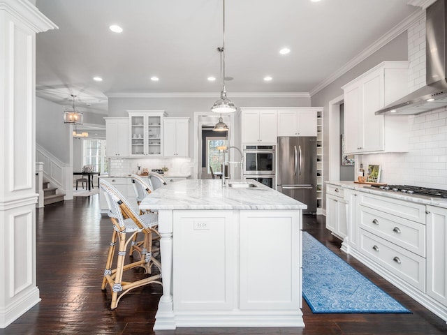 7251 Wilton Chase St, Dublin, OH 43017 - kitchen with an island with sink, wall chimney range hood, white cabinets, a sink, and stainless steel appliances